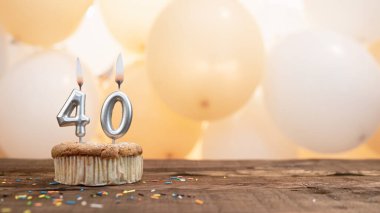 Balonların arka planında 40 numaralı mumun kekin içinde olduğu doğum günün kutlu olsun. Kopya uzay 40 yıllık doğum günün kutlu olsun..