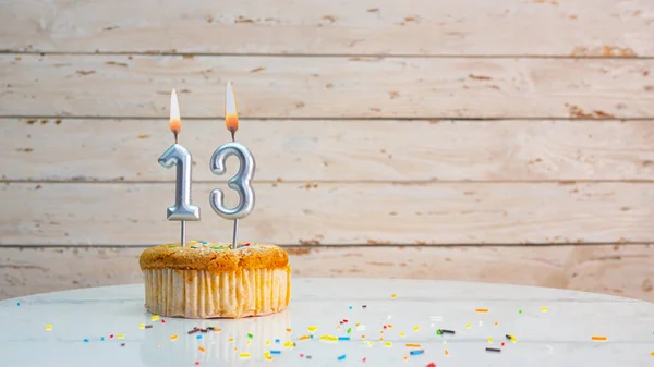 ホワイトボードのコピースペースを背景に銀の数字から13歳のための幸せな誕生日の挨拶 13年間 燃えるろうそくのあるマフィンと美しい誕生日カード — ストック写真