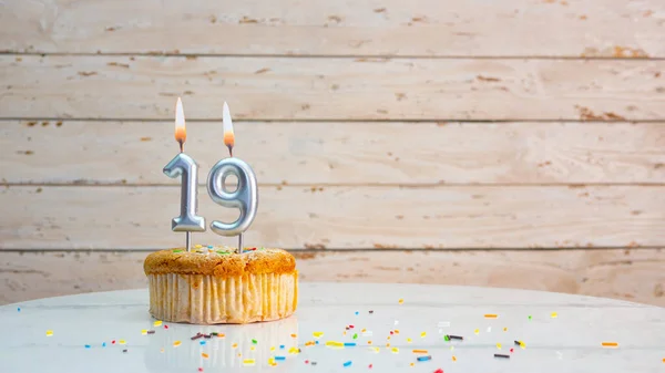 ホワイトボードのコピースペースを背景に銀の数字から19歳のための幸せな誕生日の挨拶 美しい誕生日カード19年のための燃えるろうそくとマフィン — ストック写真