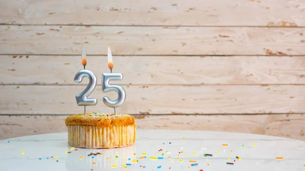 ホワイトボードのコピースペースを背景に銀の数字から25年のための幸せな誕生日の挨拶 25年のための燃えるろうそくとマフィンと美しい誕生日カード — ストック写真
