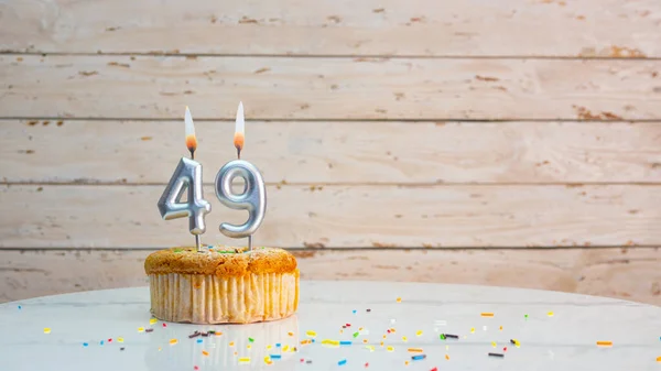 ホワイトボードのコピースペースを背景に銀の数字の49年のための幸せな誕生日の挨拶 49年のための燃えるろうそくとマフィンと美しい誕生日カード — ストック写真