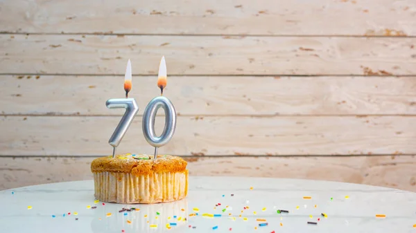 ホワイトボードの背景コピースペース上の銀の数字から幸せな70歳の誕生日の挨拶 キャンドルが点灯したカップケーキ付きの美しい誕生日カード70年 — ストック写真