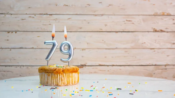 白い板の背景のコピースペースの銀の数から79年のための幸せな誕生日の願い 79年もの間 キャンドルが灯されたカップケーキ付きの美しい誕生日カード — ストック写真