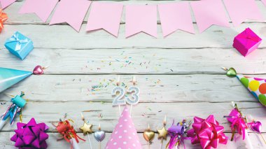 Happy birthday number 23. Copyspace. Beautiful card in pastel pink colors for a woman or a girl. Decorations festive place for your text.