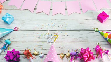 Happy birthday number 27. Copyspace. Beautiful card in pastel pink colors for a woman or a girl. Decorations festive place for your text