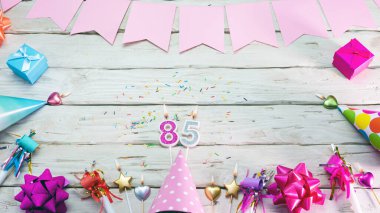 Happy birthday number 85. Copyspace. Beautiful card in pastel pink colors for a woman or a girl. Decorations festive place for your text