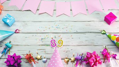 Happy birthday number 89. Copyspace. Beautiful card in pastel pink colors for a woman or a girl. Decorations festive place for your text.