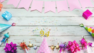 Happy birthday number 94. Copyspace. Beautiful card in pastel pink colors for a woman or a girl. Decorations festive place for your text.