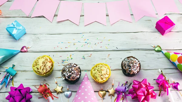 Happy birthday muffins on the table, copy space. Beautiful card in pastel pink colors for a woman or a girl. Decorations festive place for your text