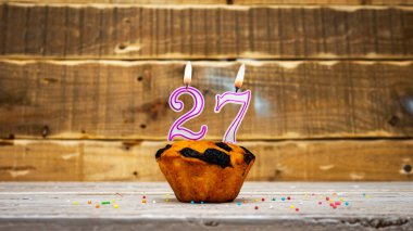 Muffin with candle burning background for anniversary. Greeting card for the holiday. Happy birthday background minimalist copy space 27