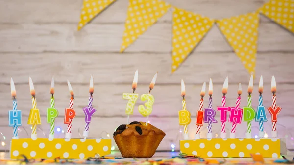 Festive card Happy Birthday with number of burning candles. Beautiful background copy space, happy birthday with digit number 73
