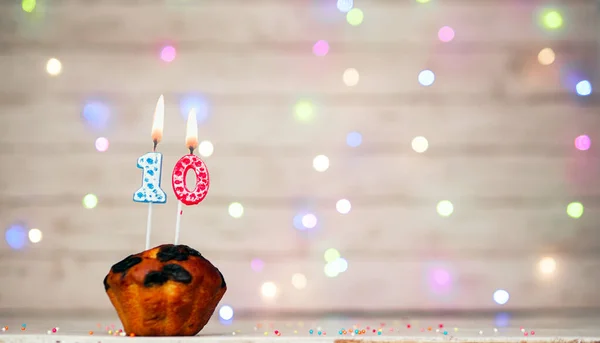 Happy birthday background with muffin and number of candles on light bulbs bokeh background. Greeting card happy birthday copy space with number  10