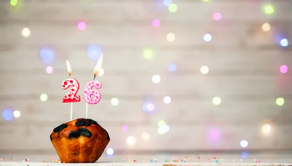 Happy birthday background with muffin and number of candles on light bulbs bokeh background. Greeting card happy birthday copy space with number 26