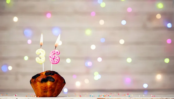 stock image Happy birthday background with muffin and number of candles on light bulbs bokeh background. Greeting card happy birthday copy space with number 36