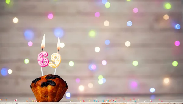 Happy birthday background with muffin and number of candles on light bulbs bokeh background. Greeting card happy birthday copy space with number 69