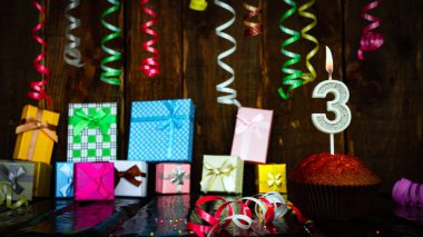 Party birthday background with number  3. Beautiful background anniversary copy space with burning candles. Gift boxes with decorations.