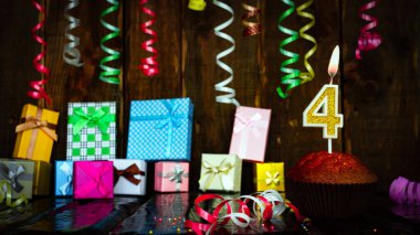 Party birthday background with number  4. Beautiful background anniversary copy space with burning candles. Gift boxes with decorations.