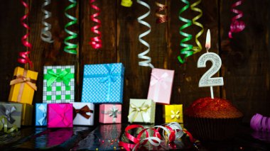 Party birthday background with number  2. Beautiful background anniversary copy space with burning candles. Gift boxes with decorations.