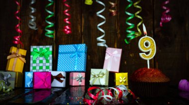 Party birthday background with number  9. Beautiful background anniversary copy space with burning candles. Gift boxes with decorations.