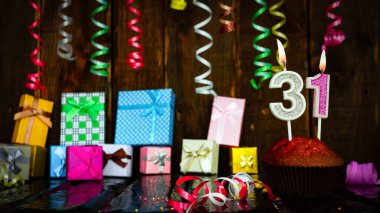Party birthday background with number  31. Beautiful background anniversary copy space with burning candles. Gift boxes with decorations.