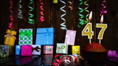 Party birthday background with number  47. Beautiful background anniversary copy space with burning candles. Gift boxes with decorations.