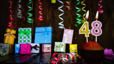 Party birthday background with number 48. Beautiful background anniversary copy space with burning candles. Gift boxes with decorations.