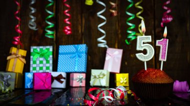 Party birthday background with number  51. Beautiful background anniversary copy space with burning candles. Gift boxes with decorations.