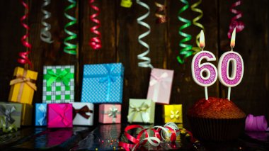 Party birthday background with number  60. Beautiful background anniversary copy space with burning candles. Gift boxes with decorations.