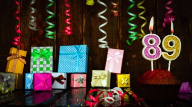 Party birthday background with number  89. Beautiful background anniversary copy space with burning candles. Gift boxes with decorations.
