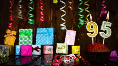 Party birthday background with number 95. Beautiful background anniversary copy space with burning candles. Gift boxes with decorations.