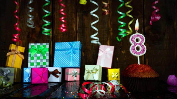 Party birthday background with number  8. Beautiful background anniversary copy space with burning candles. Gift boxes with decorations.
