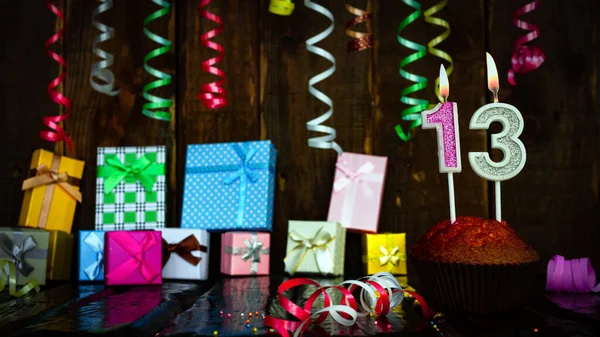 Party birthday background with number  13. Beautiful background anniversary copy space with burning candles. Gift boxes with decorations.