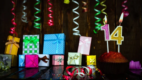Party birthday background with number  14. Beautiful background anniversary copy space with burning candles. Gift boxes with decorations.