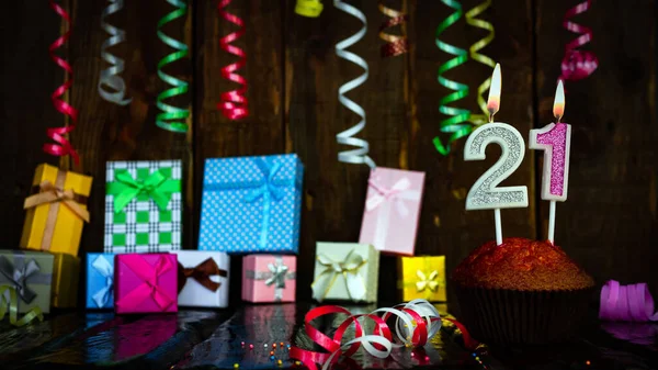 Party birthday background with number  21. Beautiful background anniversary copy space with burning candles. Gift boxes with decorations.