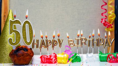 Happy birthday background with golden candles and decorations with candles burning number  50. Colorful festive card happy birthday with a number. Anniversary copy space
