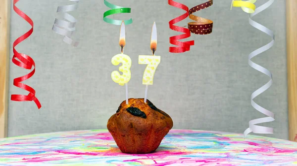 Happy birthday background with muffin with beautiful decorations with number candles  37. Colorful festive card happy birthday with a number. Anniversary copy space