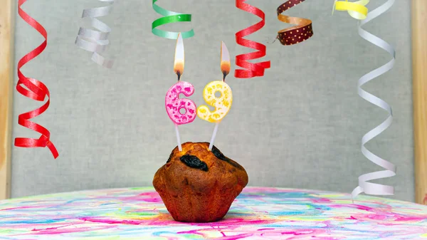 Happy birthday background with muffin with beautiful decorations with number candles  69. Colorful festive card happy birthday with a number. Anniversary copy space
