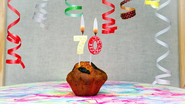 Happy birthday background with muffin with beautiful decorations with number candles  70. Colorful festive card happy birthday with a number. Anniversary copy space