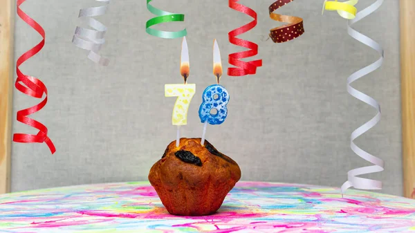 Happy birthday background with muffin with beautiful decorations with number candles  78. Colorful festive card happy birthday with a number. Anniversary copy space