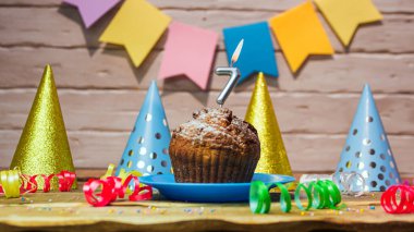 Festive cake with a candle with a number  7. Happy birthday background with beautiful decorations.Anniversary party copy space.
