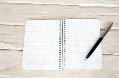 Üzerinde siyah tuşlu kalem olan bir kafesin içinde boş bir sayfa olan üst görünüm not defteri. Metin için boşluk.