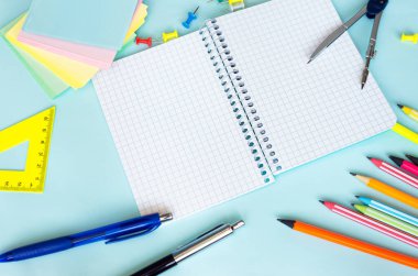 İş planörü kopyalama alanı. Metin için boş sayfası olan not defteri. Kalemle yazma notları. Etiketler çok renkli üst görünüm. Kalem kırtasiye arka planına sahip kalemler.