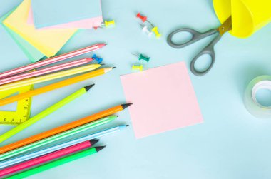 İş planörü kopyalama alanı. Metin için boş sayfası olan not defteri. Kalemle yazma notları. Etiketler çok renkli üst görünüm. Mavi desen üzerine kalem kırtasiye arka planına sahip kalemler.