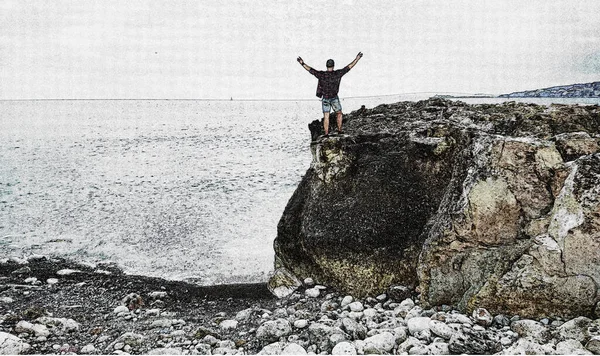Happy man on top of a mountain with his hands up in the background of the sea. Dreamy man on the mountain. The man looks at the sea.