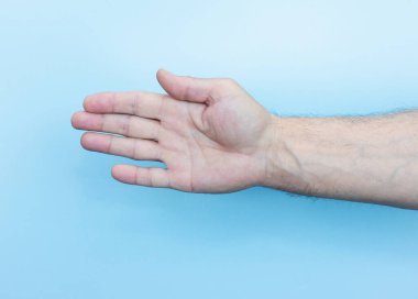 The hand of an elderly man on a blue background. Old man man's hand close-up. Man's palm. body language, hand gestures