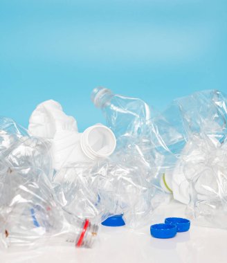 Top view Empty twisted plastic bottles on a blue background. Used plastic bottles trash. Caring for ecology concept.