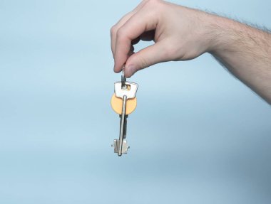 The concept of buying a house or apartment. Keys in a man's hand copy space. Real estate. Buying real estate background.