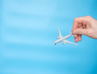 A gray passenger plane in a man's hand. Airplane model, flight simulation, travel concept