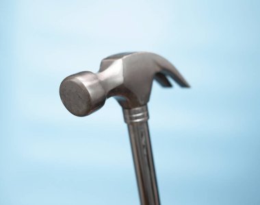 Close-up Hammer construction nail puller on a blue background. Imitation of hammering nails. Construction or renovation concept. copy space