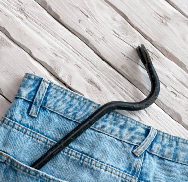 Gvozdodeo vintage with scratches in the pocket of denim pants. The concept of repair and construction, construction tools in the pocket of the chaton.